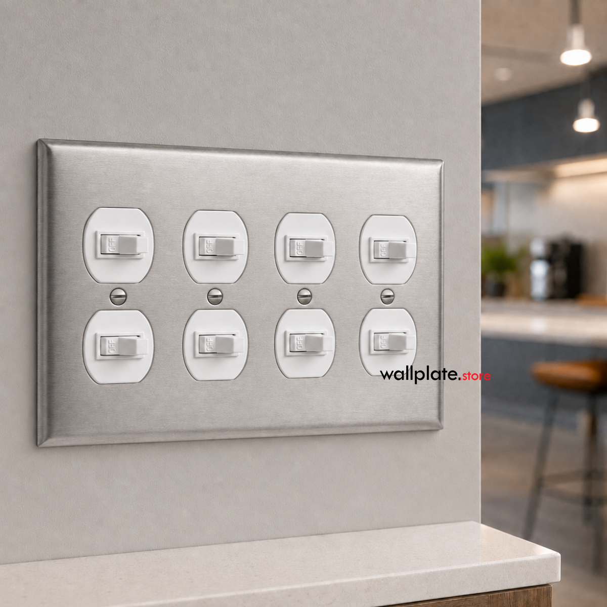 A brushed nickel stainless steel 4 Gang eight-light switch plate with eight individual toggle switches, mounted on a light gray wall in a modern kitchen setting.
